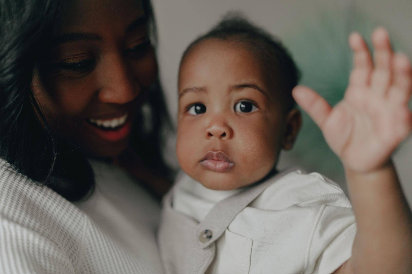 A smiling carer holding a baby close